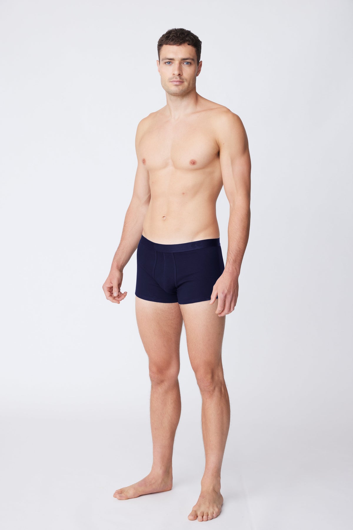 Brunet, white male wearing navy trunks