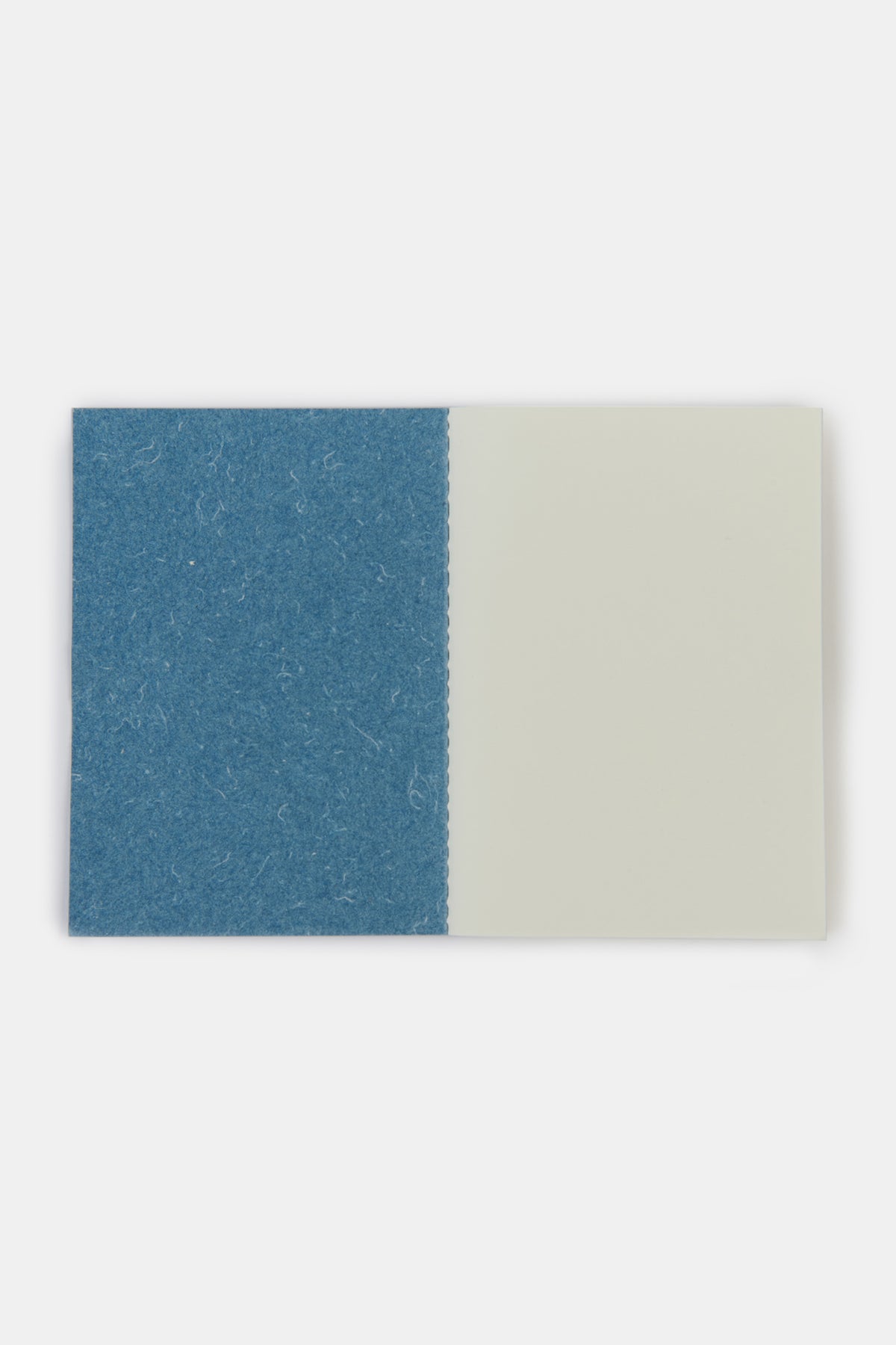 Community Clothing x Mark + Fold notebook in blue open to the front page showing the plain pages of the notebook