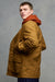 Thigh up image of brunet male wearing car coat in dark tan zipped up over hooded sweatshirt in cinnamon, paired with cameraman pants in navy