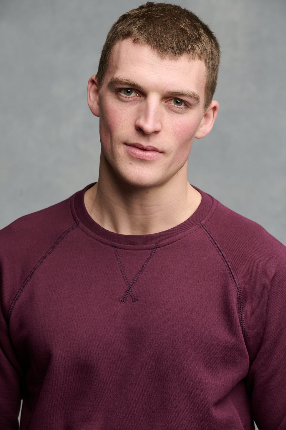 Portrait of brunet male wearing raglan sweatshirt in plum
