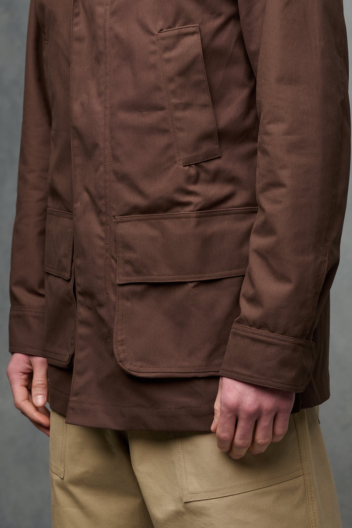 Close up of the front pockets and button fastening at the hem of sleeve