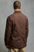 Thigh up image of male wearing men's car coat in brown unzipped over Breton in ecru cinnamon paired with cameraman pant in putty