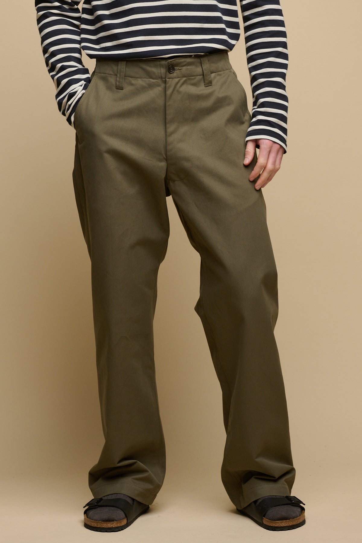 
            Chest down image of male wearing field trousers in olive with hand in front pocket, worn with Breton and sandals