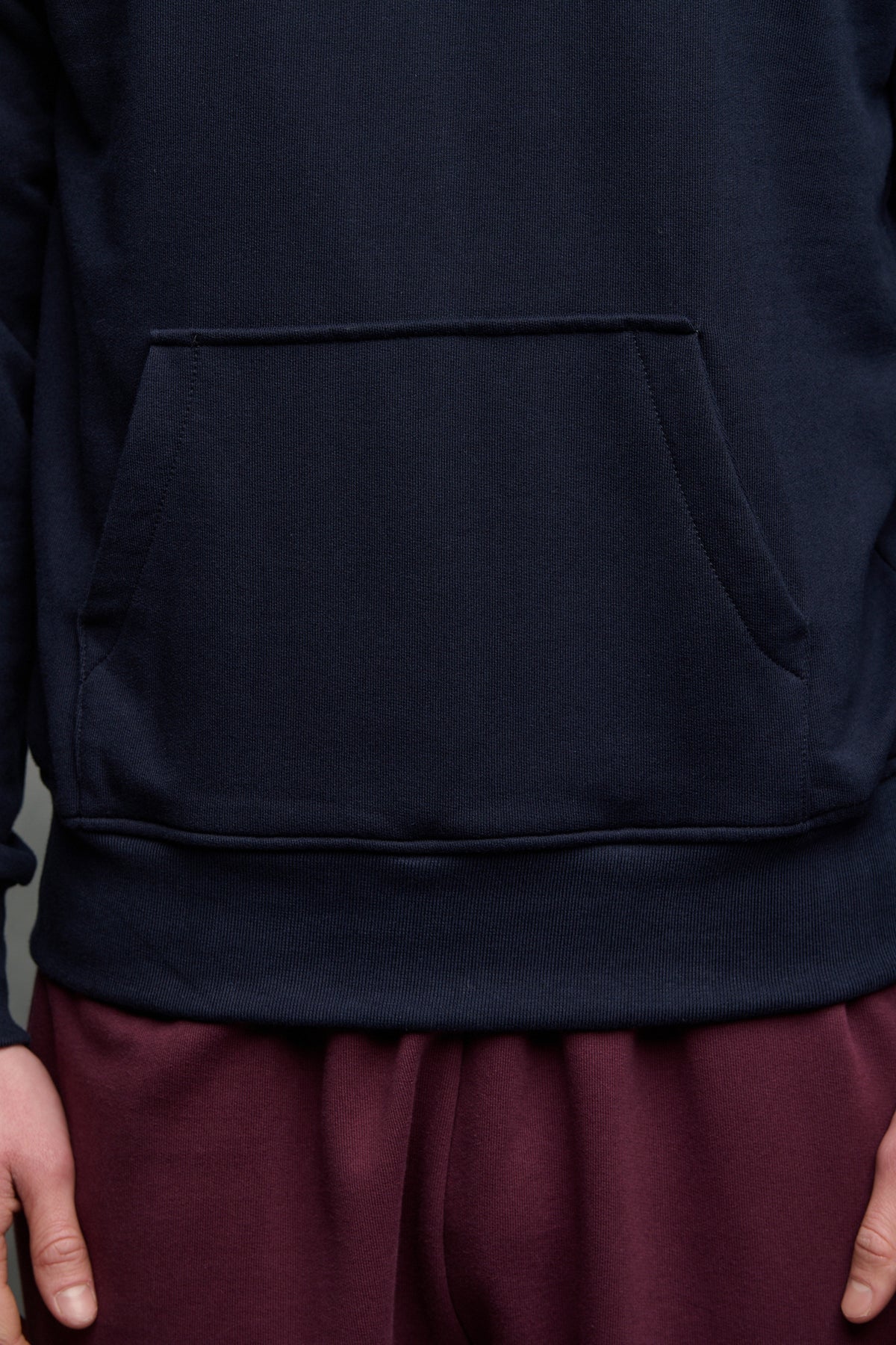 Front pocket detail of hooded sweatshirt in navy