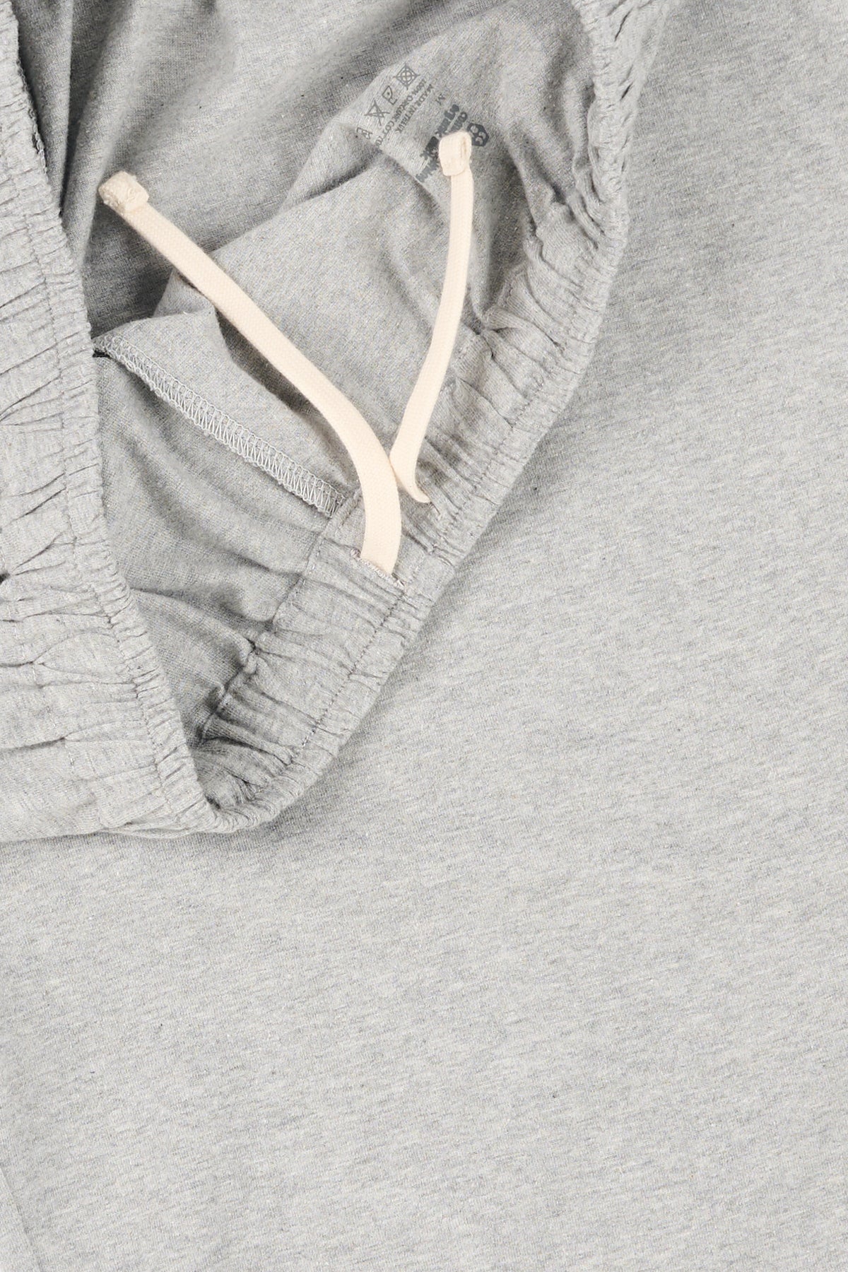 Inside waistband of mens jersey shorts with ecru drawcord. 