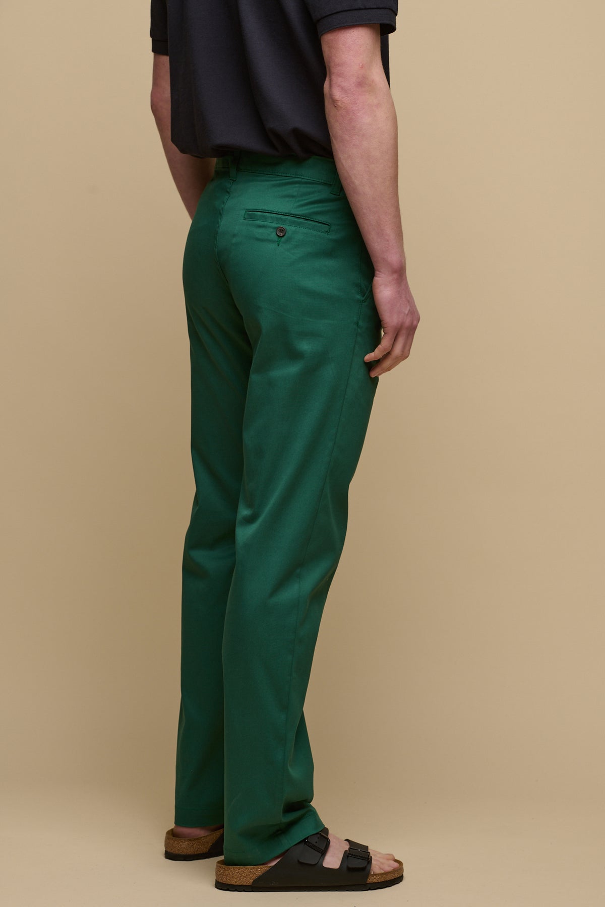 The back of male wearing slim stretch chino in bottle green with short sleeve polo shirt tucked in