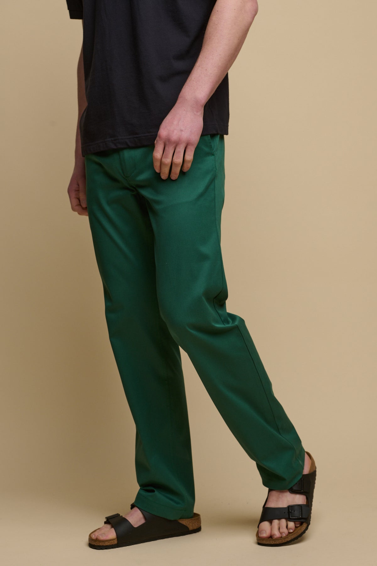 Chest down image of male wearing slim stretch chino in bottle green with sandals