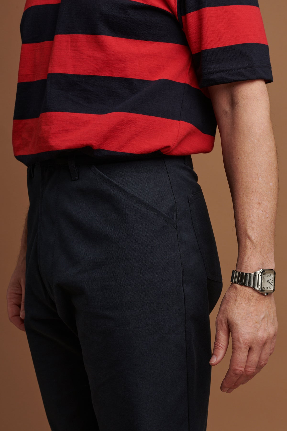 Close up of the canvas chore trousers in navy showing front pockets and belt loops
