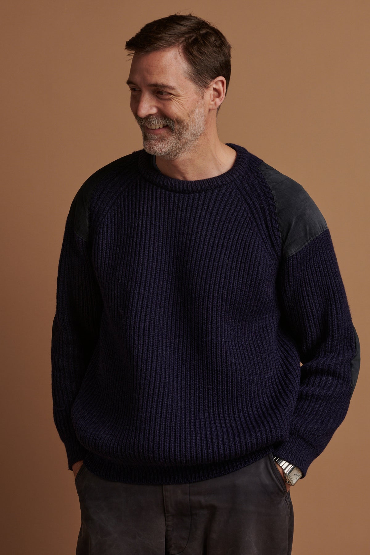 
            Patrick Grant in his favourite jumper, the lambswool fisherman ribbed jumper in navy with suede shoulder and elbow patches