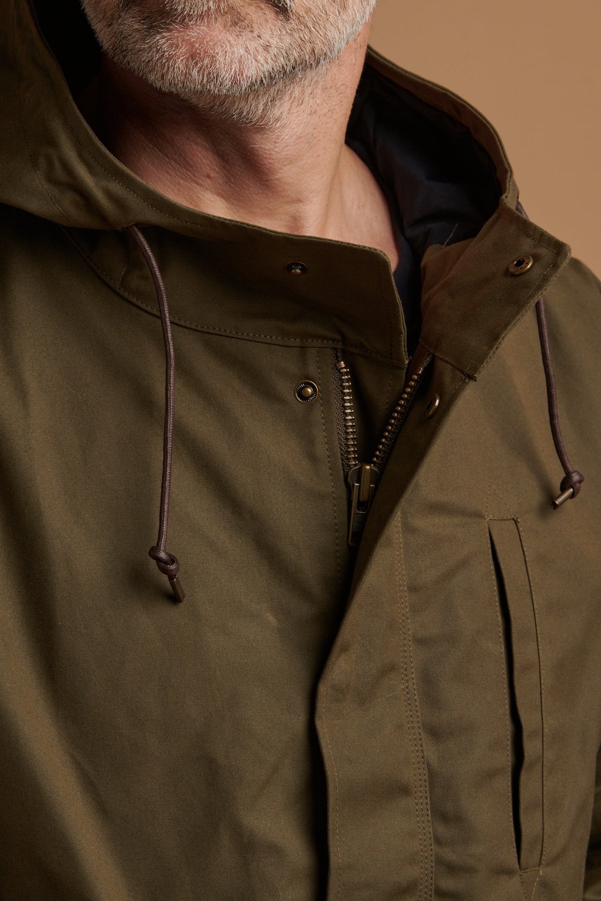 Close up of the front details showing drawcord through the hood and chest pocket