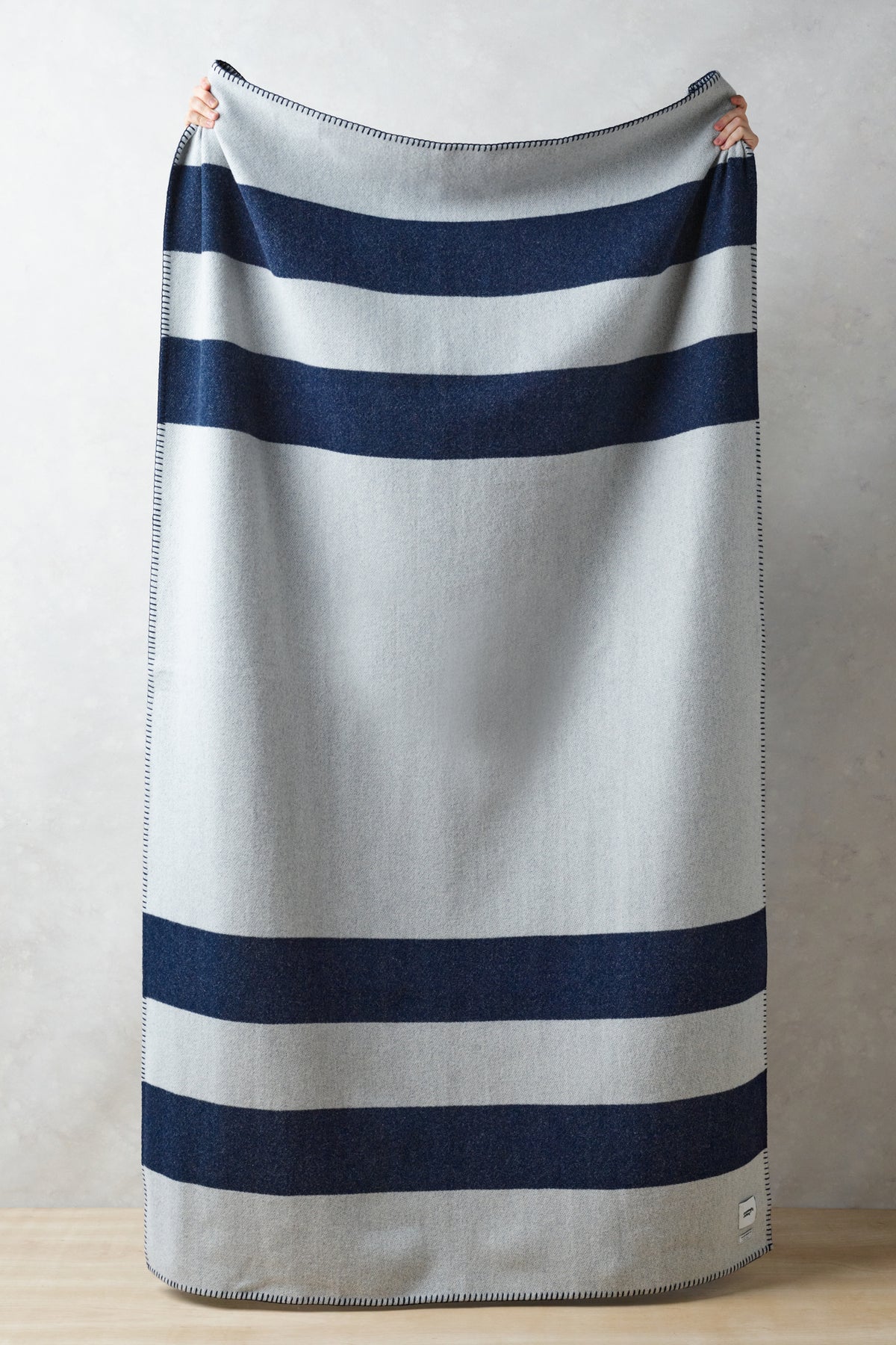 
            Image showing full length of pure wool striped blanket in navy ecru