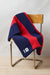 Community clothing pure wool, navy and red striped blanket draped over chair