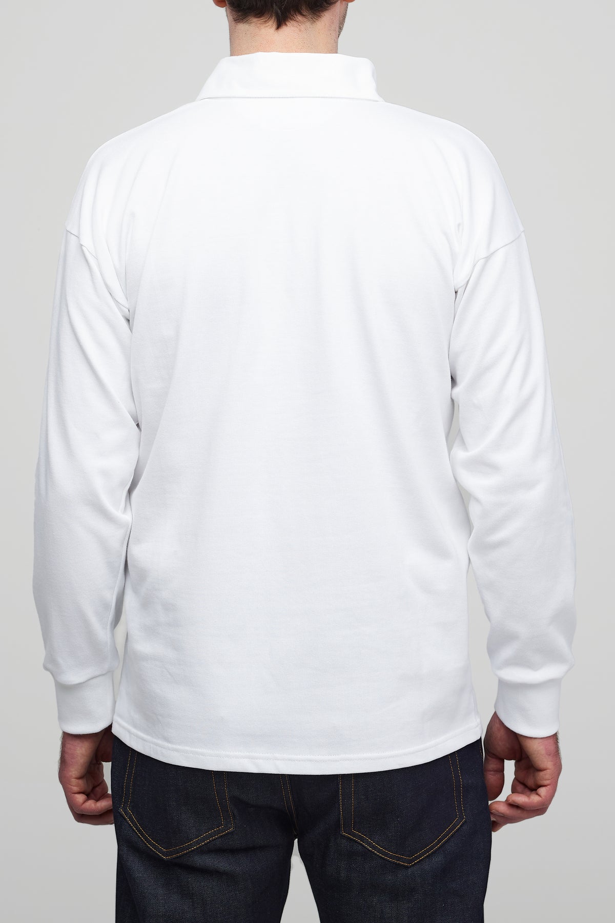 
            Thigh up image of the back of male wearing white rugby shirt