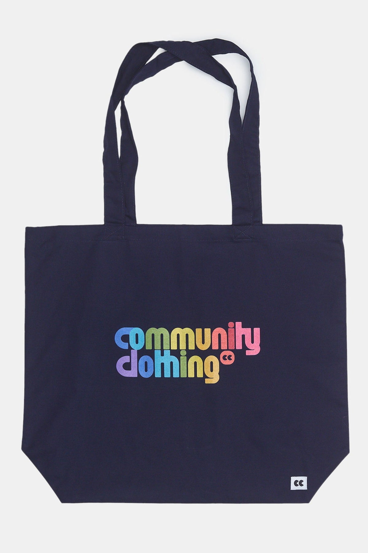 
            product shot of navy tote bag with Community Clothing rainbow logo