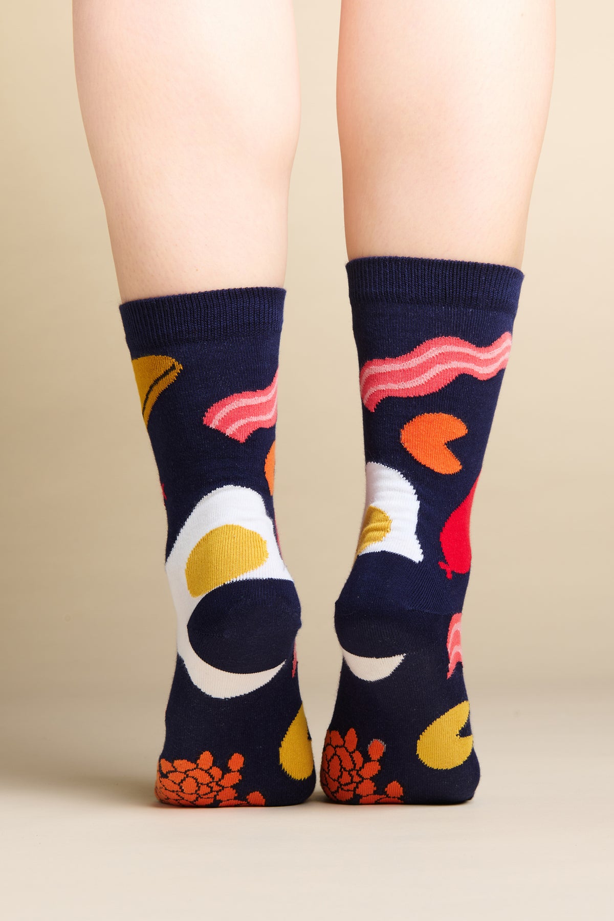 Model stood on toes, showing the back of heels and base of foot wearing navy full english design sock.