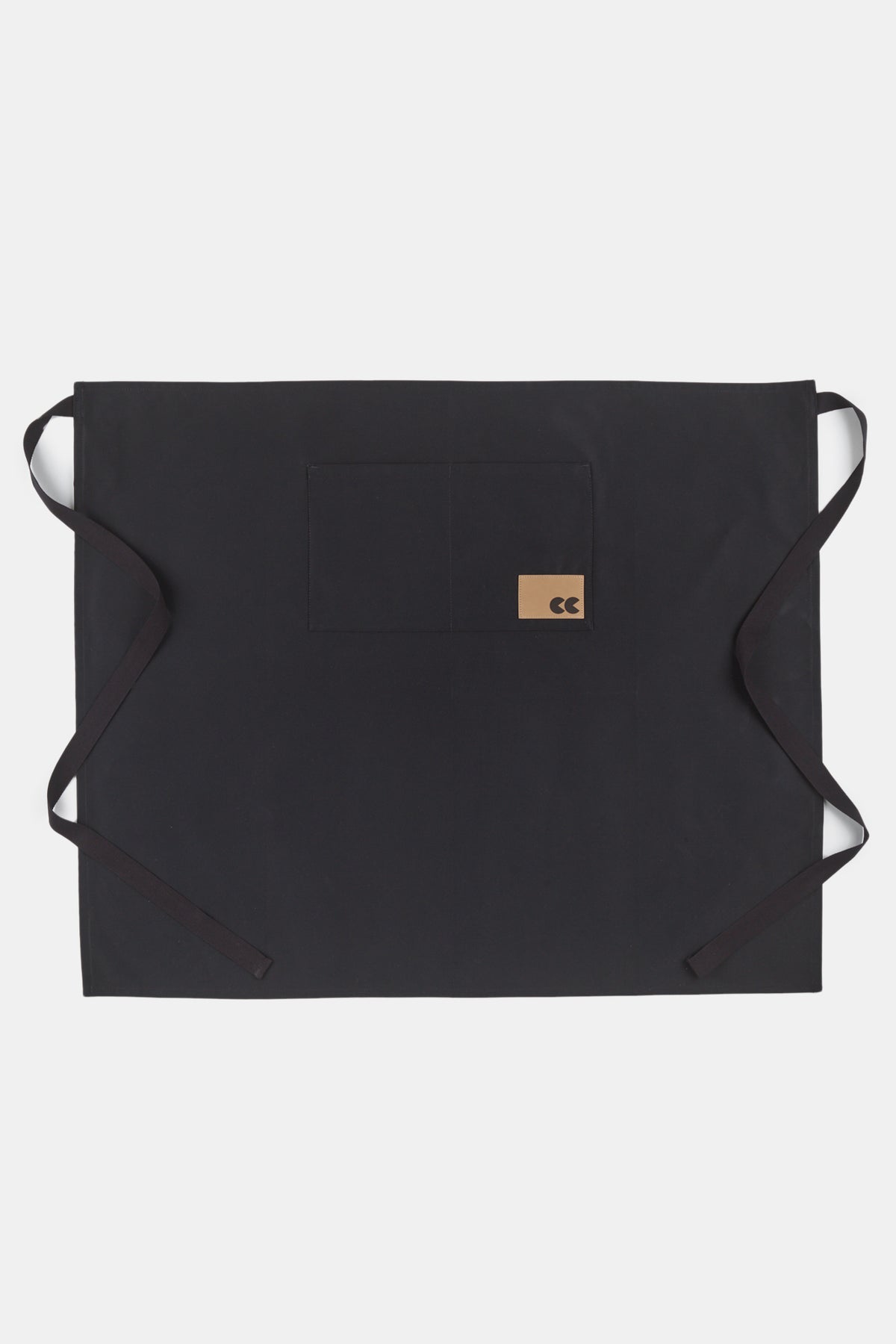 Flatlay image of unisex half apron in black with front pocket and CC logo patch