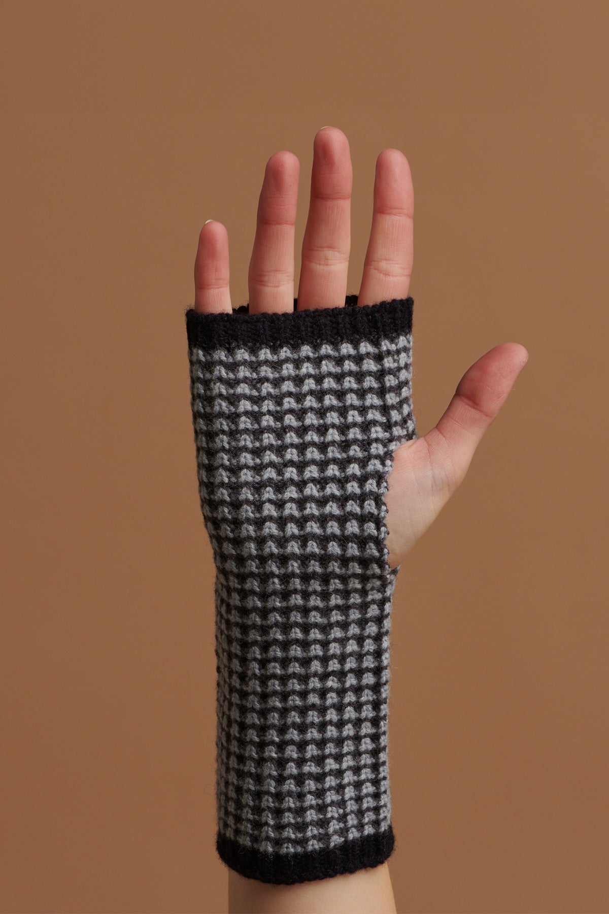 
            Hand wearing fingerless waffle knit gloves in dark navy 