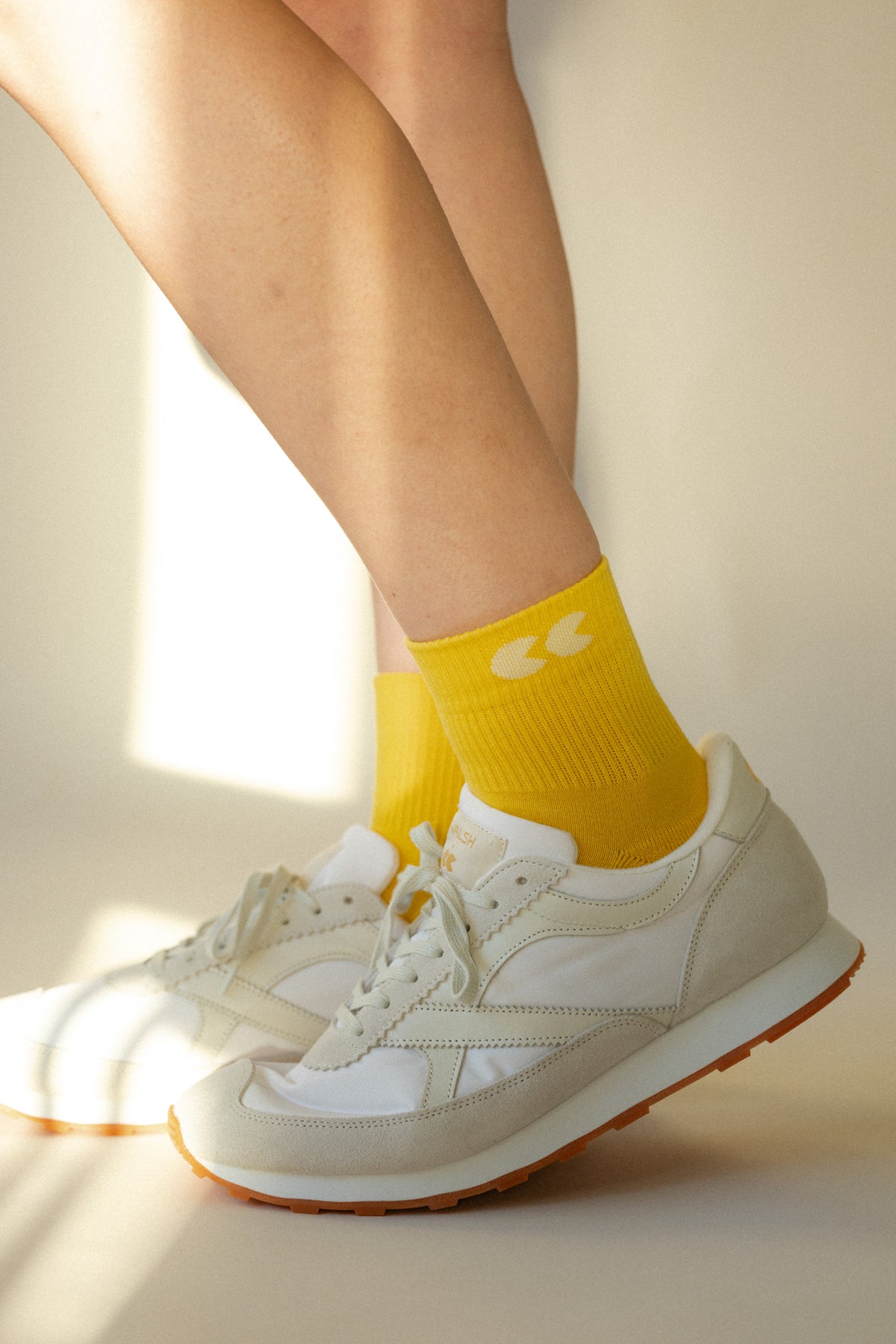 Unisex sports ankle socks in canary yellow worn with Community Clothing x Walsh Trainers in white