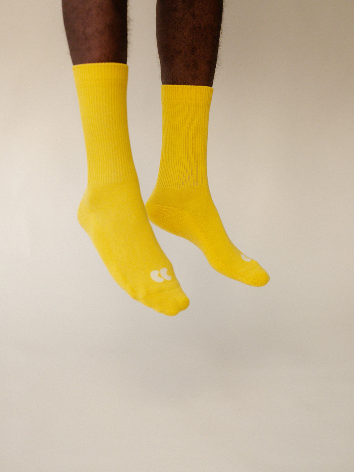 
            image of male legs mid jump  wearing unisex sports calf sock in canary yellow