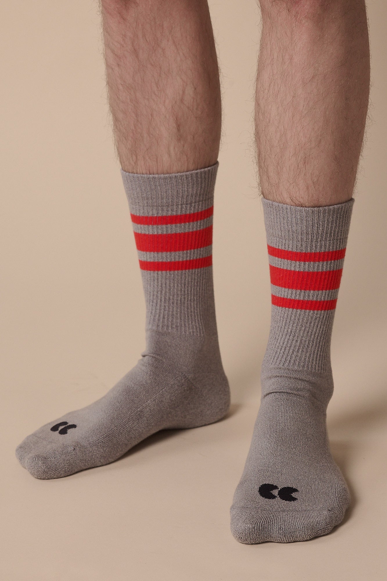 Model wearing sports cotton sock 3 pack in grey and red stripe with CC logo on toe