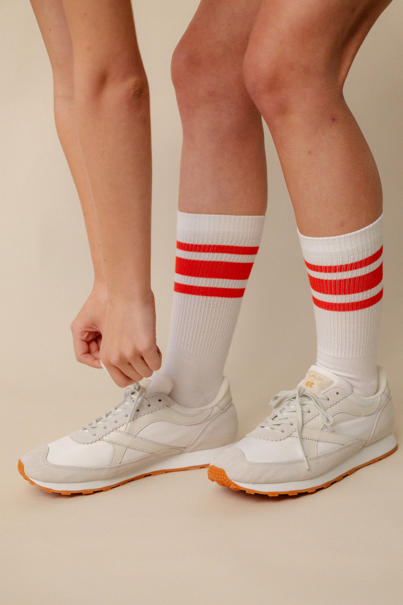 Model wearing calf sports sock in white with flame red stripe wearing Wlash X Community Clothing Beacon trainers