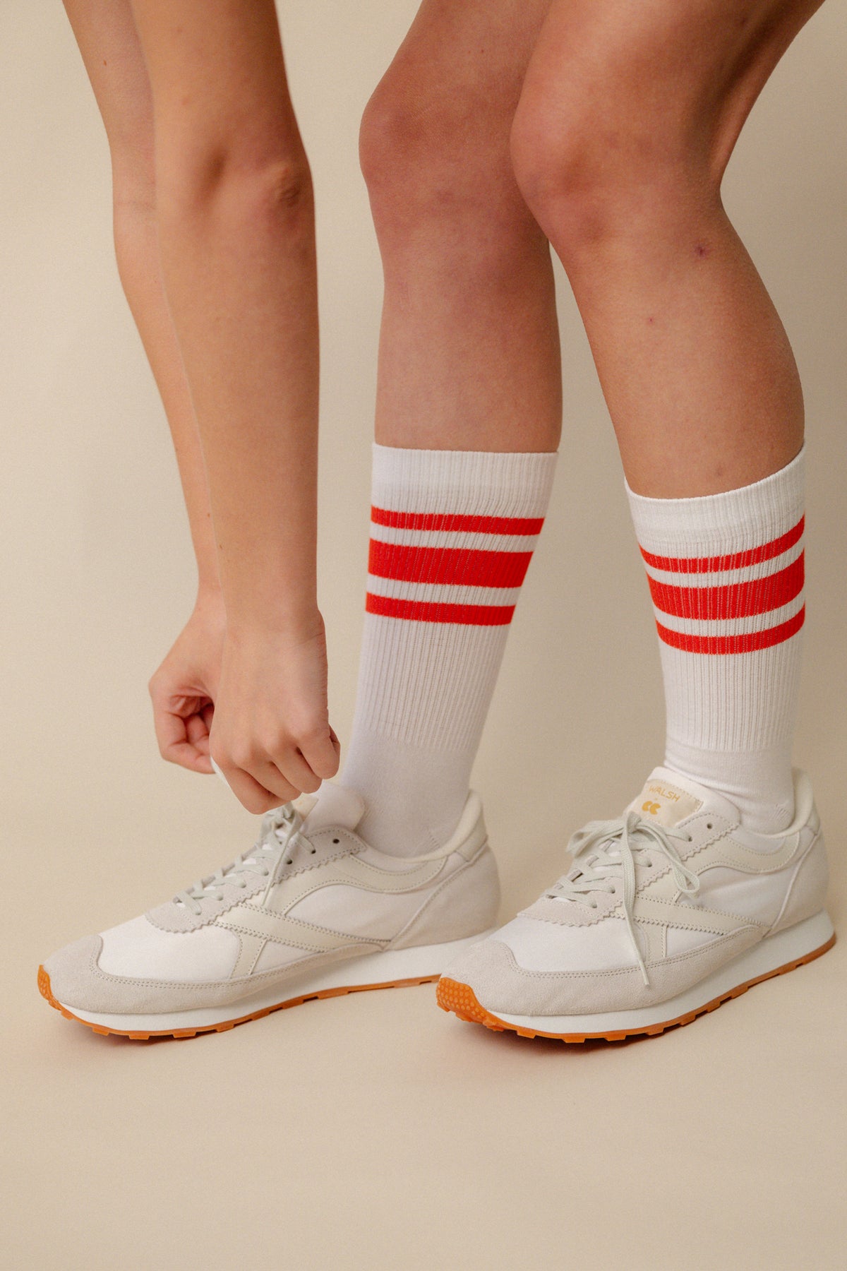 
            Model wearing calf sports sock in white with flame red stripe wearing Wlash X Community Clothing Beacon trainers