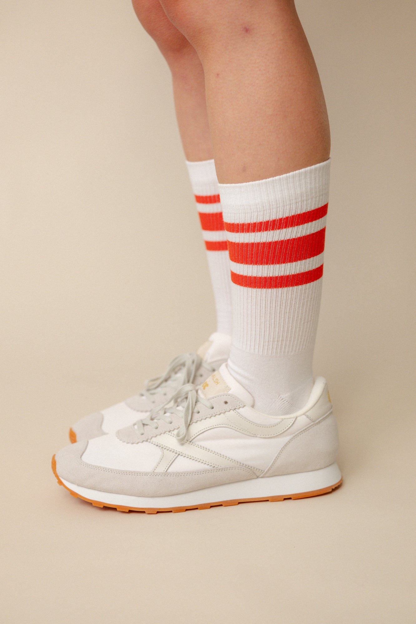 Model wearing calf sports sock in white with flame red stripe wearing Wlash X Community Clothing Beacon trainers