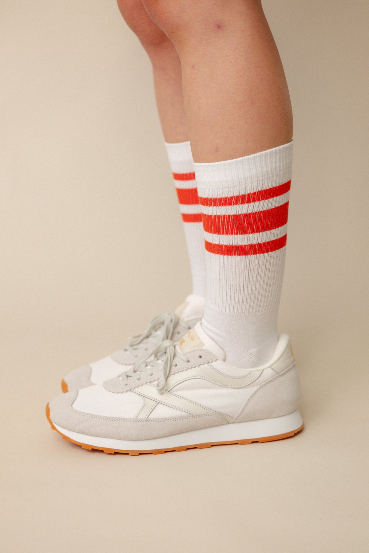 
            Model wearing calf sports sock in white with flame red stripe wearing Wlash X Community Clothing Beacon trainers