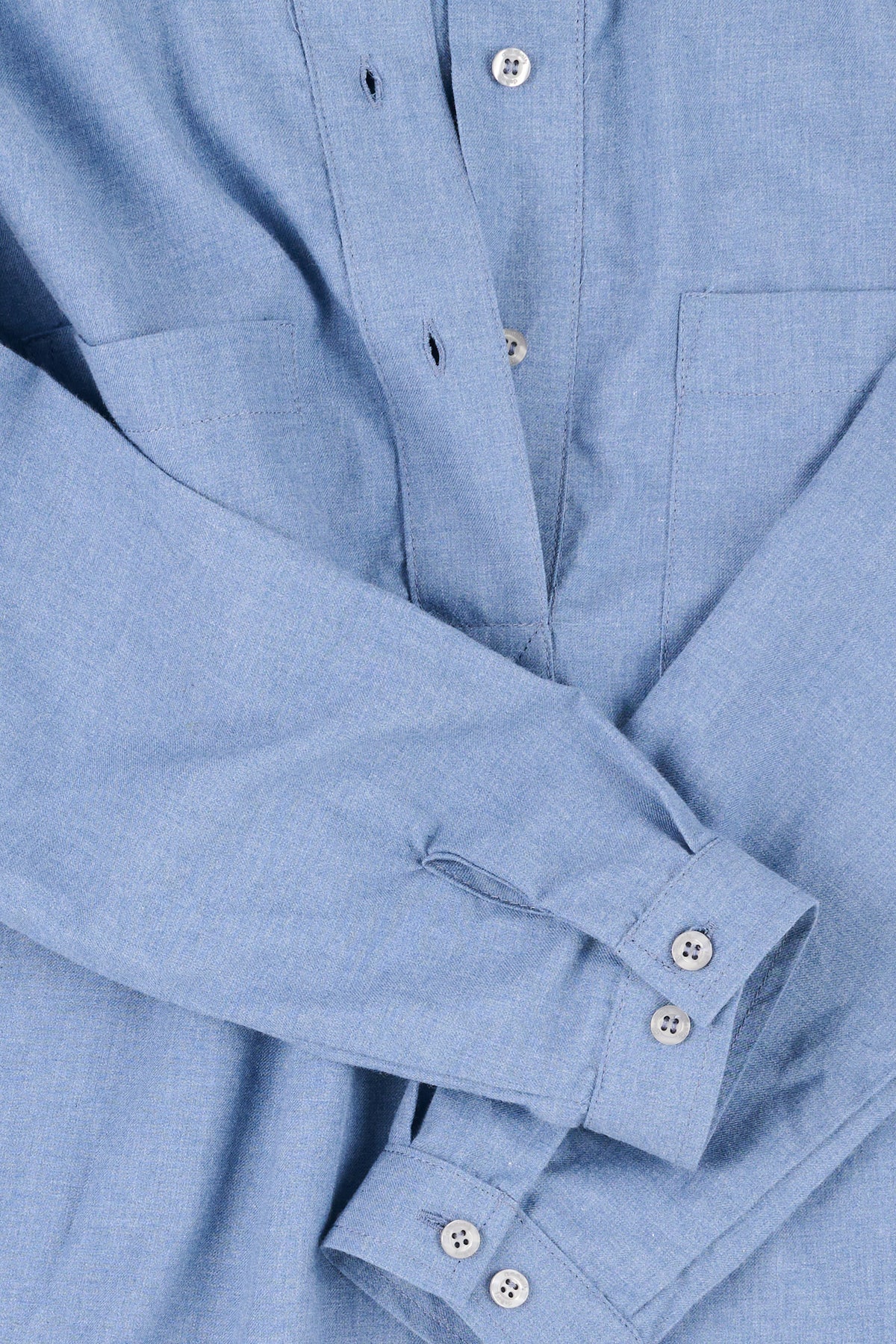 Close up of a half placket blue shirt with button up cuffs