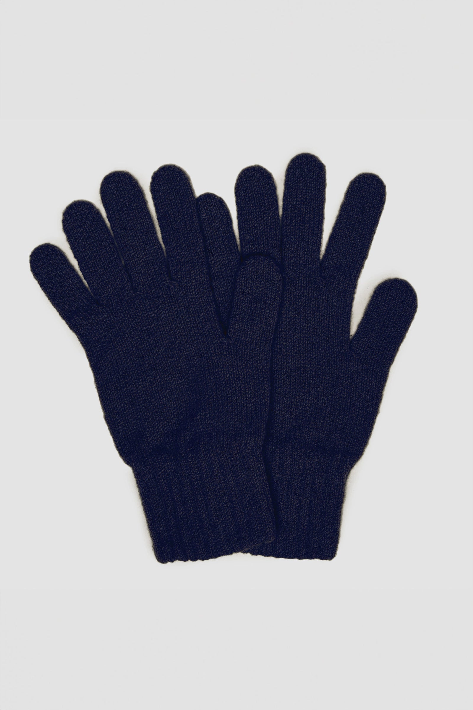 Hand wearing navy lambswool gloves holding the 'hand horns' or rock hand gesture symbol
